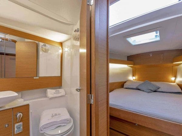 Head of the Dufour Grand Large 430 with towels on the toilette and the cabin is to the right in the next room